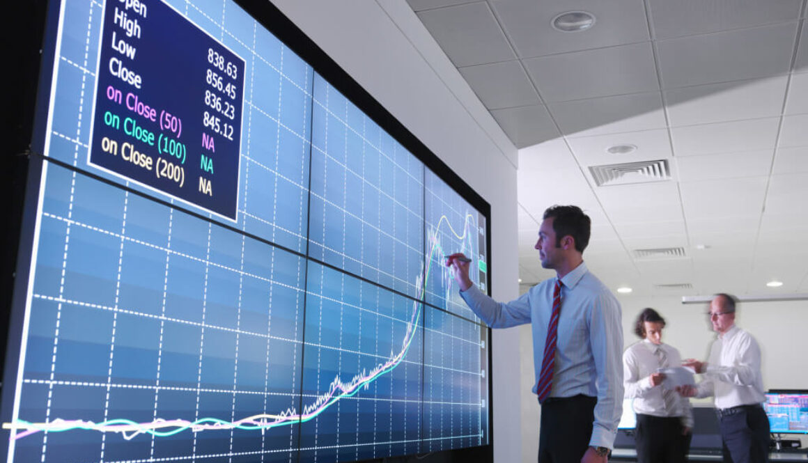 Businessman using graphs on screen